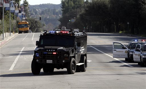 
 A police vehicle drives past El Camino Real High School in the Woodland Hills section of Los Angeles, Wednesday, Jan. 19, 2011. A school police officer was shot near the high school but his bulletproof vest took the hit Wednesday, one day after an accidental shooting wounded two students at a school on the other side of the city, authorities said. (AP Photo/Jae C. Hong)
 