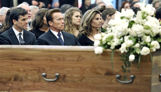 
 Timothy Shriver, left, former California Gov. Arnold Schwarzenegger, center, and his wife Maria Shriver listen to during the funeral Mass for R. Sargent Shriver, near his flower-laden casket at Our Lady of Mercy Catholic church in Potomac, Md., Saturday, Jan. 22, 2011. Shriver, an in-law of the Kennedys, and the first director of the Peace Corps, died Tuesday. He was 95. (AP Photo/Cliff Owen, Pool)
 