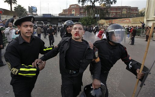 
 A wounded riot policeman is led away by colleagues as Egyptian riot police clash with anti-government activists in downtown Cairo, Egypt, Wednesday, Jan. 26, 2011. Egyptian anti-government activists clashed with police for a second day Wednesday in defiance of an official ban on any protests but beefed up police forces on the streets quickly moved in and used tear gas and beatings to disperse demonstrations. (AP Photo/Ben Curtis)
 
