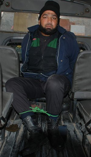 
 Commando of Pakistan's Elite force Mumtaz Qadri, who allegedly killed Punjab's governor Salman Taseer sits in a police vanin Islamabad, Pakistan on Tuesday, Jan. 4, 2011. An intelligence official interrogating the suspect, identified as Mumtaz Qadri, told The Associated Press that the bearded elite force police commando was boasting about the assassination, saying he was proud to have killed a blasphemer. The governor of Pakistan's powerful Punjab province was shot dead Tuesday by one of his guards in the Pakistani capital, police said, the killing was the most high-profile assassination of a political figure in Pakistan since the slaying of former Prime Minister Benazir Bhutto in December of 2007. (AP Photo/Irfan Ali)
 