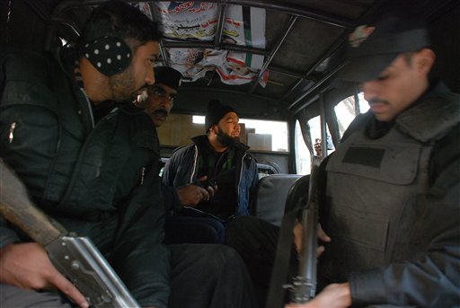
 Commando of Pakistan's Elite force Mumtaz Qadri, center, who allegedly killed Punjab's governor Salman Taseer sits in a police van in Islamabad, Pakistan on Tuesday, Jan. 4, 2011. An intelligence official interrogating the suspect, identified as Mumtaz Qadri, told The Associated Press that the bearded elite force police commando was boasting about the assassination, saying he was proud to have killed a blasphemer. The governor of Pakistan's powerful Punjab province was shot dead Tuesday by one of his guards in the Pakistani capital, police said, the killing was the most high-profile assassination of a political figure in Pakistan since the slaying of former Prime Minister Benazir Bhutto in December of 2007. (AP Photo/Tariq Waseem)
 
