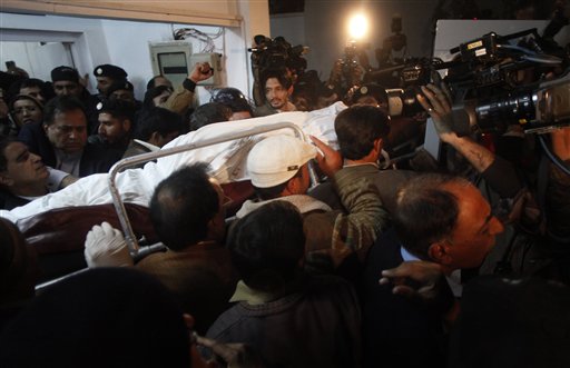 
 People carry dead body of Punjab's governor Salman Taseer who was shot dead by one of his guards, to an ambulance at a local hospital in Islamabad, Pakistan on Tuesday, Jan. 4, 2011. The governor of Pakistan's powerful Punjab province was shot dead Tuesday by one of his guards in the Pakistani capital, police said, the killing was the most high-profile assassination of a political figure in Pakistan since the slaying of former Prime Minister Benazir Bhutto in December of 2007. (AP Photo/B.K.Bangash)
 