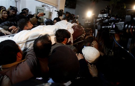
 People carry dead body of Punjab's governor Salman Taseer who was shot dead by one of his guards, to an ambulance at a local hospital in Islamabad, Pakistan on Tuesday, Jan. 4, 2011. The governor of Pakistan's powerful Punjab province was shot dead Tuesday by one of his guards in the Pakistani capital, police said, the killing was the most high-profile assassination of a political figure in Pakistan since the slaying of former Prime Minister Benazir Bhutto in December of 2007. (AP Photo/B.K.Bangash)
 