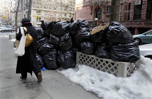 
 A woman walks by bags of uncollected trash on New York's Upper West Side, Thursday, Jan. 6, 2011. Another storm took aim at New York City, where Mayor Michael Bloomberg was still under fire for slow cleanup of a stubborn winter blast that kept streets clogged for days and delayed trash pickups, causing uncollected garbage to pile up for more than a week. (AP Photo/Richard Drew)
 