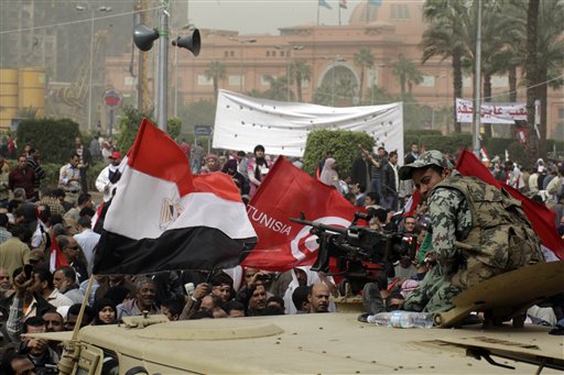
 An Egyptian army soldier watches thousands of Egyptian gather at Tahrir Square, the focal point of the Egyptian uprising, flashing Egyptian and Tunisan flags in Cairo, Egypt, Friday, Feb.25, 2011. The deputy to Osama bin Laden issued al-Qaida's second message since the Egyptian uprising, accusing the nation's Christian leadership of inciting interfaith tensions and denying that the terror network was behind last month's bombing of a Coptic church in Alexandria that killed 21 and sparked protests. (AP Photo/Amr Nabil)
 