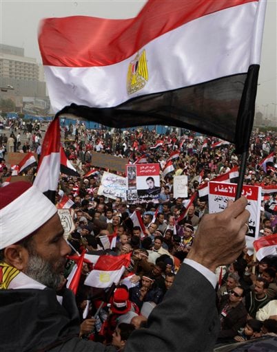 
 An Egyptian Muslim Sheikh, waves Egyptian flag as thousands gather at Tahrir Square, the focal point of the Egyptian uprising, in Cairo, Egypt, Friday, Feb.25, 2011.The deputy to Osama bin Laden issued al-Qaida's second message since the Egyptian uprising, accusing the nation's Christian leadership of inciting interfaith tensions and denying that the terror network was behind last month's bombing of a Coptic church in Alexandria that killed 21 and sparked protests. (AP Photo/Amr Nabil)
 