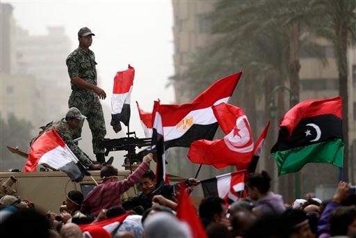 
 Egyptian army officers guard on top of an armored vehicle as demonstrators wave the Egyptian, Tunisian and Libya's old national flags in the Tahrir Square in Cairo, Egypt, Friday, Feb.25, 2011.The deputy to Osama bin Laden issued al-Qaida's second message since the Egyptian uprising, accusing the nation's Christian leadership of inciting interfaith tensions and denying that the terror network was behind last month's bombing of a Coptic church in Alexandria that killed 21 and sparked protests. (AP Photo/Khalil Hamra)
 