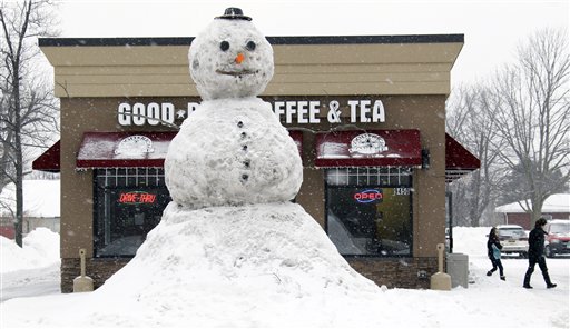 
 Customers leave a coffee shop with a large snowman on display in Clarence, N.Y., Wednesday, Feb. 2, 2011. (AP Photo/David Duprey)
 