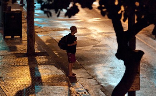 
 A man stands on the sidewalk on Kalakaua Avenue in Waikiki, Hawaii as a reported tsunami heads toward the Hawaiian Islands early Friday, March 11, 2011 in Honolulu. Tsunami waves hit Hawaii in the early morning hours Friday and were sweeping through the island chain after an earthquake in Japan sparked evacuations throughout the Pacific and as far as the U.S. western coast. The Pacific Tsunami Warning Center said Kauai was the first of the Hawaiian islands hit by the tsunami. Water rushed ashore in Honolulu, swamping the beach in Waikiki and surging over the break wall in the world-famous resort but stopping short of the area's high-rise hotels. (AP Photo/Eugene Tanner)
 