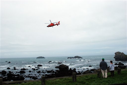 
 A Coast Guard helicopter flies above Pebble Beach in Crescent City, Calif. on Friday, March 11, 2011 where onlookers watch for the predicted surges of a tsunami. The first small surge was spotted at 7:38 a.m. and continued. (AP Photo/Jeff Barnard)
 