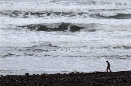 
 A lone person walks on the beach when a surge from a tsunami from the Japanese earthquake is expected in Seaside, Ore., Friday, March, 11, 2011. Oregon's coastal residents cleared out ahead of the first waves of a tsunami to hit the U.S. mainland, but the effects in Oregon were minor. (AP Photo/Don Ryan)
 