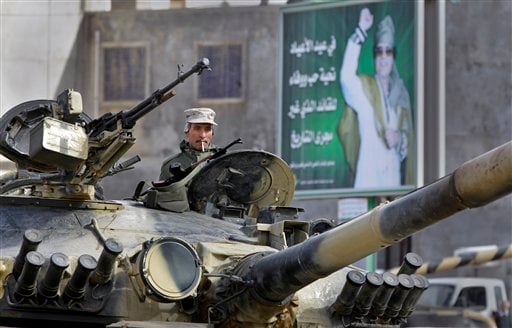 
 A Libyan army soldier loyal to Libyan Leader Moammar Gadhafi, poster in background, sits in a tank, in Qasr Banashir, southeast of the capital Tripoli, in Libya, Tuesday, March 1, 2011. Government opponents in rebel-held Zawiya repelled an attempt by forces loyal to Moammar Gadhafi to retake the city closest to the capital in six hours of fighting overnight, witnesses said Tuesday. (AP Photo/Ben Curtis)
 
