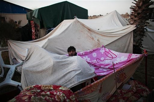 
 Bangladeshi workers who have been trying to leave Libya for over six days wake up in the morning in a makeshift tent as they wait to be evacuated in the eastern city of Benghazi, Libya, on Tuesday, March 1, 2011. (AP Photo/Tara Todras-Whitehill)
 