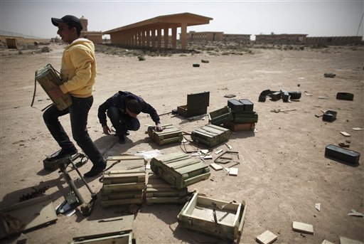 
 Libyan volunteers take ammunition from inside an army base to be used for the defense against any further Libyan air force raids in the eastern town of Ajdabiya, Libya, on Tuesday March 1, 2011. The U.N. Security Council have imposed an arms embargo on Gadhafi, four of his sons and a daughter and leaders of revolutionary committees accused of much of the violence against opponents, urged an international freeze on Libyan assets and authorized an investigation into Ghadafi's regime for possible crimes against humanity. (AP Photo/Tara Todras-Whitehill)
 