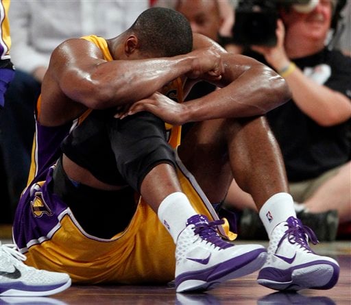 
 Los Angeles Lakers' Andrew Bynum holds his knee on the floor after being hurt during the first half of an NBA basketball game against the San Antonio Spurs in Los Angeles, Tuesday, April 12, 2011. Bynum hyperextended his right knee. (AP Photo/Chris Carlson)
 