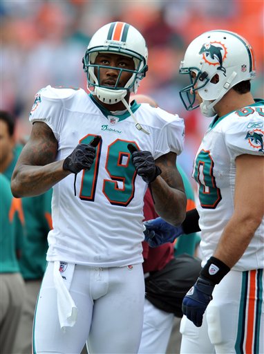 
 FILE - This Dec. 19, 2010, file photo shows Miami Dolphins wide receiver Brandon Marshall (19) talking with teammate Anthony Fasano (80) on the sidelines during an NFL football game against the Buffalo Bills, in Miami. Marshall's wife is accused of stabbing the Miami Dolphins wide receiver and has been arrested on a domestic violence charge, according to a police report. The report, which was posted on The South Florida Sun Sentinel's website, says Michi Nogami-Marshall stabbed her husband with a kitchen knife Friday, April 22, 2011. (AP Photo/Steve Mitchell, File)
 