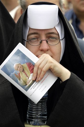 
 A nun holds a leaflet as she follows a thanksgiving Mass in St. Peter's Square at the Vatican, Monday, May 2, 2011. Tens of thousands of Catholic faithful have filled St. Peter's Square for a Mass of thanksgiving for the beatification of John Paul II. The Mass is being celebrated by the Vatican No. 2, Cardinal Tarcisio Bertone. Among the large crowds entering the square Monday were many Poles overjoyed at Sunday's beatification of the Polish-born pontiff. After Sunday's beatification, about 250,000 faithful filed past John Paul's simple wooden coffin in St. Peter's Basilica. The pope had been buried in the grottoes underneath the church, but his closed casket was brought to the church's center aisle ahead of the beatification. (AP Photo/Pier Paolo Cito)
 