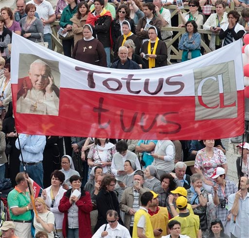 
 Faithful hold a banner reading in latin Totus tuus (Totally yours) during a thanksgiving Mass in St. Peter's Square at the Vatican, Monday, May 2, 2011. Tens of thousands of Catholic faithful have filled St. Peter's Square for a Mass of thanksgiving for the beatification of John Paul II. The Mass is being celebrated by the Vatican No. 2, Cardinal Tarcisio Bertone. Among the large crowds entering the square Monday were many Poles overjoyed at Sunday's beatification of the Polish-born pontiff. After Sunday's beatification, about 250,000 faithful filed past John Paul's simple wooden coffin in St. Peter's Basilica. The pope had been buried in the grottoes underneath the church, but his closed casket was brought to the church's center aisle ahead of the beatification. (AP Photo/Gregorio Borgia)
 