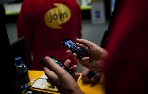 
 A worker from Joyn uses a phone to send a message at the world's largest mobile phone trade show in Barcelona, Spain, Thursday March 1, 2012. The new messaging method introduced by the industry group GSMA, or Groupe Speciale Mobile Association, is dubbed 'Joyn' and will be launched this year by operators in France, Germany, Italy and South Korea. They do it by offering messaging applications that let phone users chat for free on the carriers' data networks or Wi-Fi. (AP Photo/Emilio Morenatti)
 
